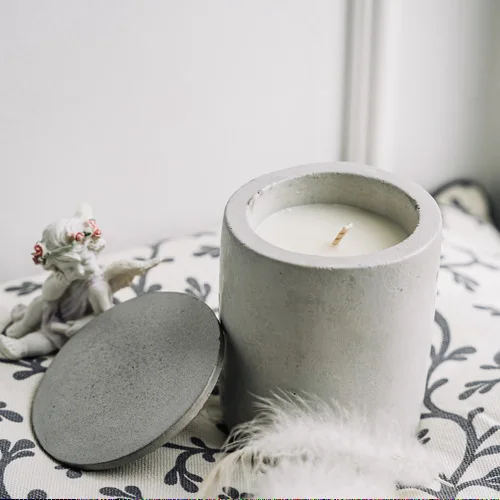 A candle in a plaster candlestick with a lid, with a fragrance