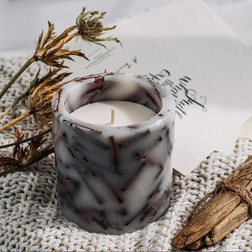 A candle in a paraffin candle holder with a natural decor inside, with a fragrance